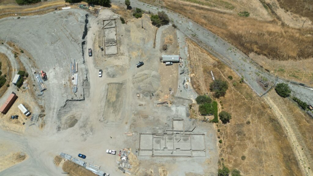 Drone view of All Access Construction preparing the Milpitas carport slab site in Santa Clara County with a full overview of the work area and Silicon Valley backdrop.