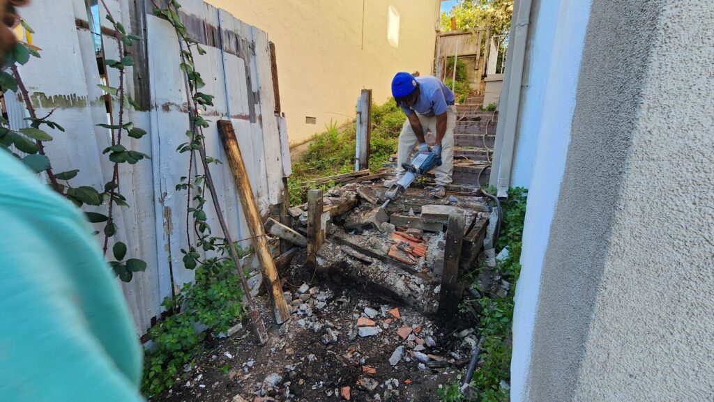 All Access Construction jackhammering and demolishing old failing concrete stairs on a Belmont hillside.