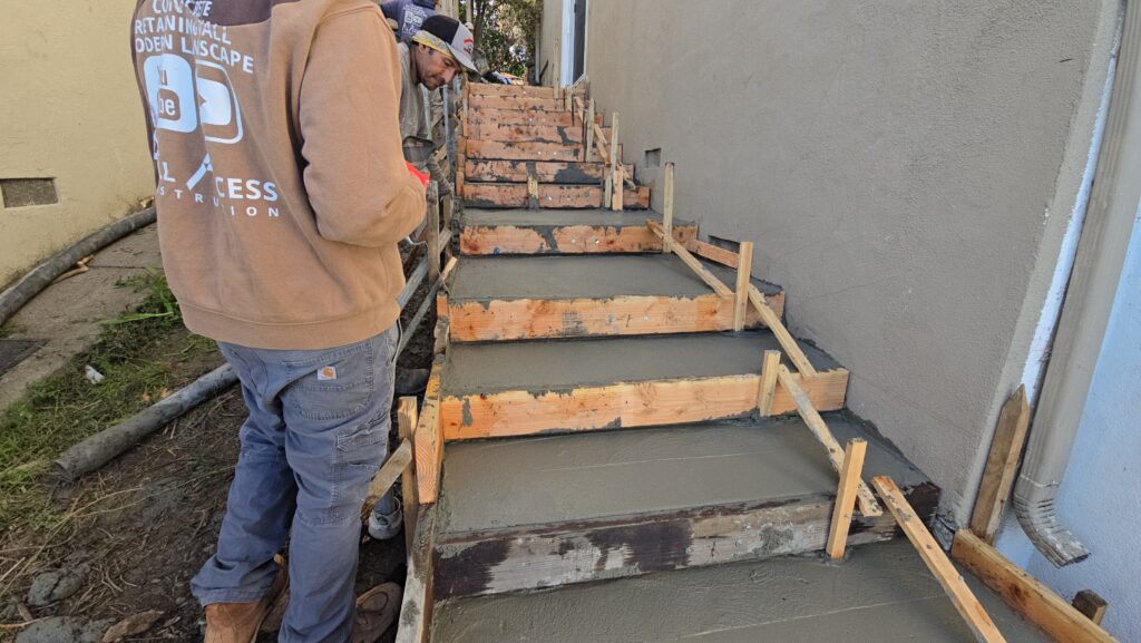 All Access Construction finishing newly poured concrete stairs on a Belmont hillside.
