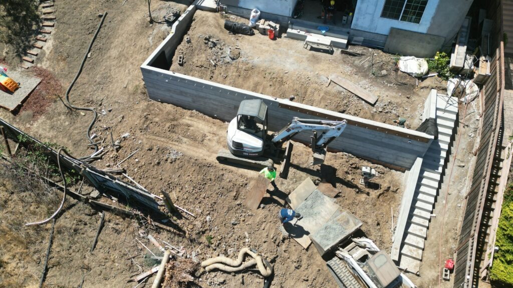 All Access Construction corner view of L-shaped concrete retaining wall in Belmont showing clean structural lines and moisture ports.