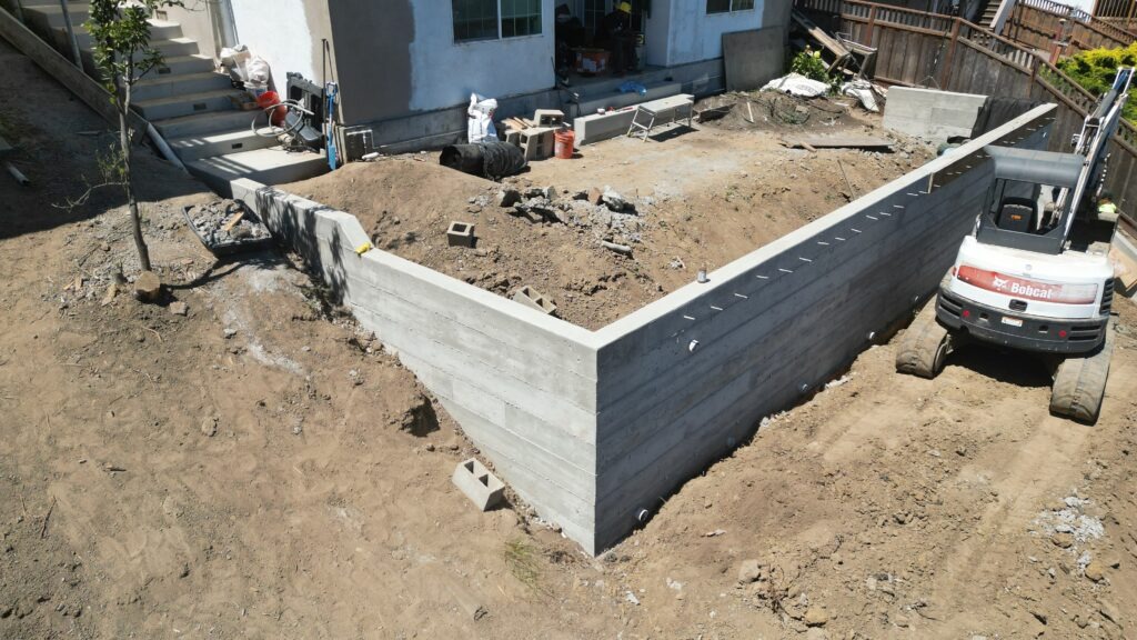 All Access Construction corner view of L-shaped concrete retaining wall in Belmont showing clean structural lines and moisture ports.