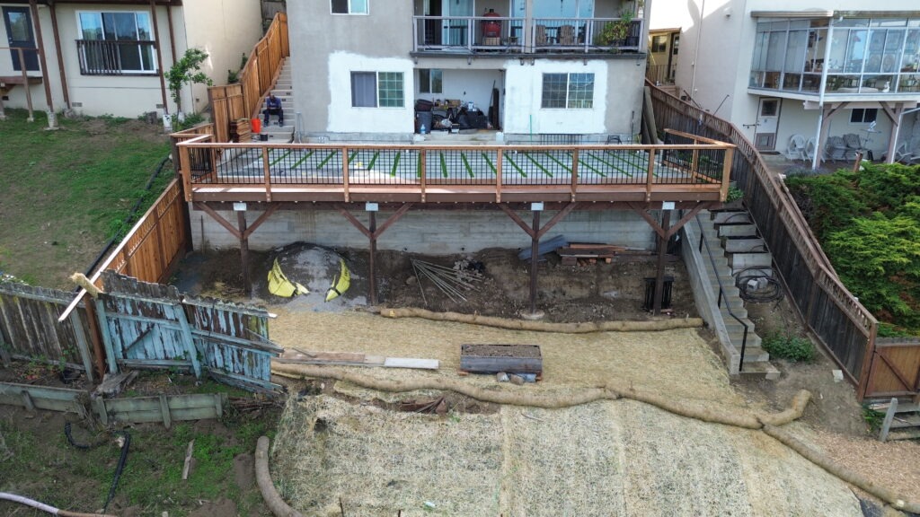 All Access Construction drone photo of backyard restoration over new Belmont retaining wall including erosion control and deck framing.