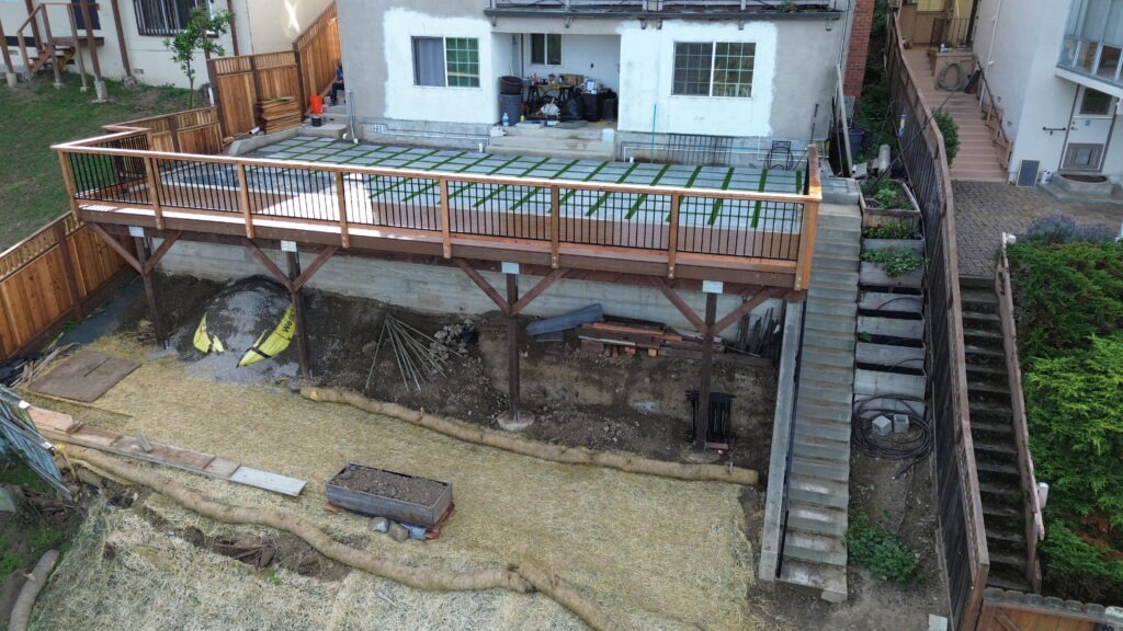 All Access Construction final drone view of completed retaining wall and elevated deck system above the new concrete wall in Belmont.