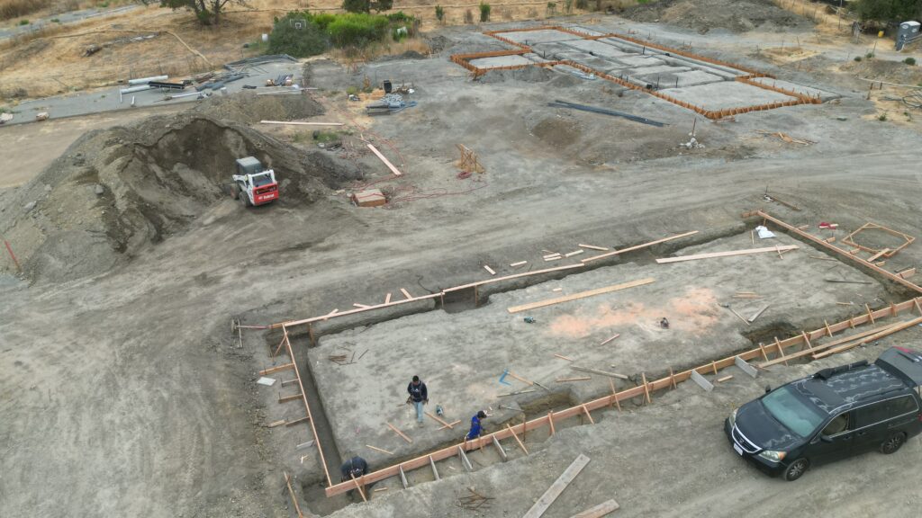 Aerial view of All Access Construction trenching and setting forms for a concrete carport slab in Milpitas.