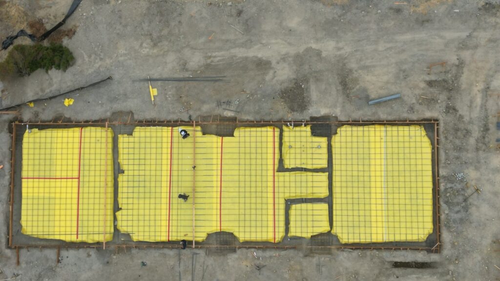 All Access Construction installing rebar grid and vapor barrier for agricultural shed concrete slab foundation.