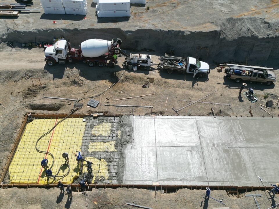 All Access Construction pouring concrete for agricultural shed foundation slab with pump truck and crew in Milpitas