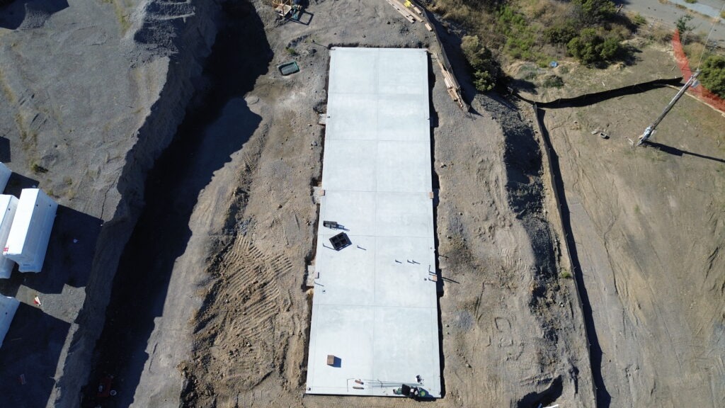 All Access Construction long concrete foundation slab built for agricultural shed installation, drone top-down view.