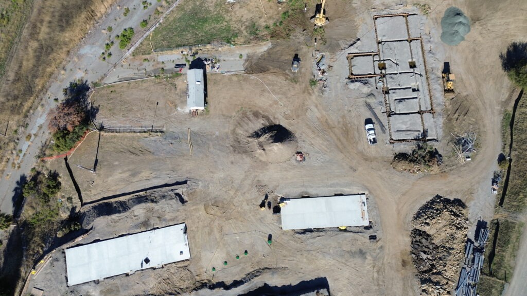 Wide drone view showing multiple concrete slab areas being prepared by All Access Construction across the Milpitas jobsite.