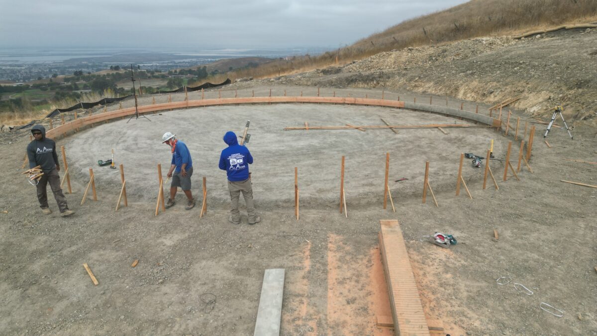 All Access Construction building 50-foot radius concrete water tank foundation in Milpitas with round formwork and hillside grading