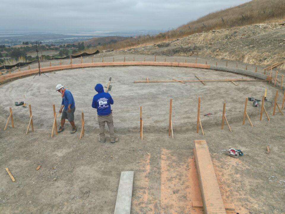 All Access Construction building 50-foot radius concrete water tank foundation in Milpitas with round formwork and hillside grading