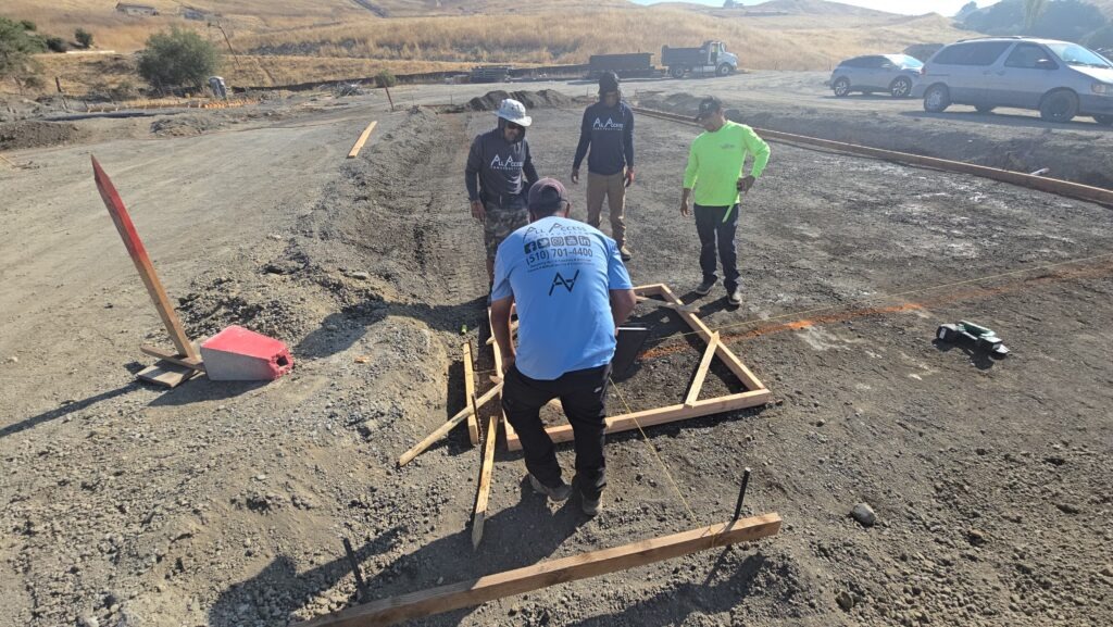 All Access Construction crew laying out carport foundation slab in Milpitas with string lines and grading prep.