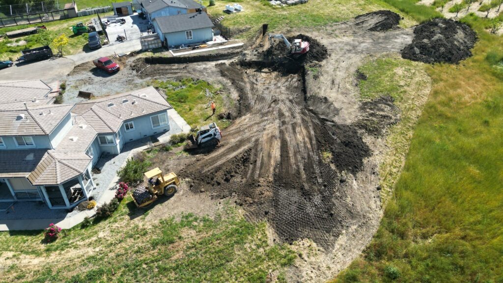 All Access Construction aerial view of Milpitas hillside concrete driveway and fire truck turnaround connecting to luxury home construction with drainage tanks and surrounding grading
