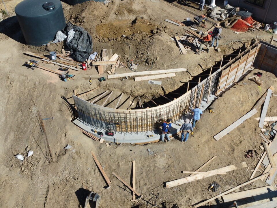 Aerial drone shot showing progress of 50 foot long curved retaining wall in Milpitas CA near San Jose