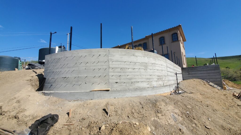 Finished 6 foot tall curved concrete retaining wall on a hillside property in Milpitas California near San Jose Santa Clara County after construction