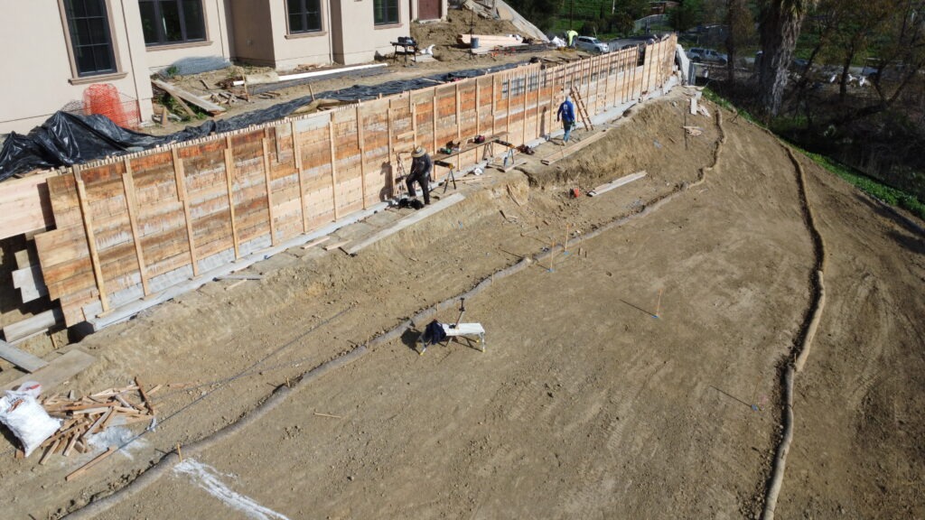 Detailed forming work for long concrete retaining wall with heavy reinforcement in Milpitas