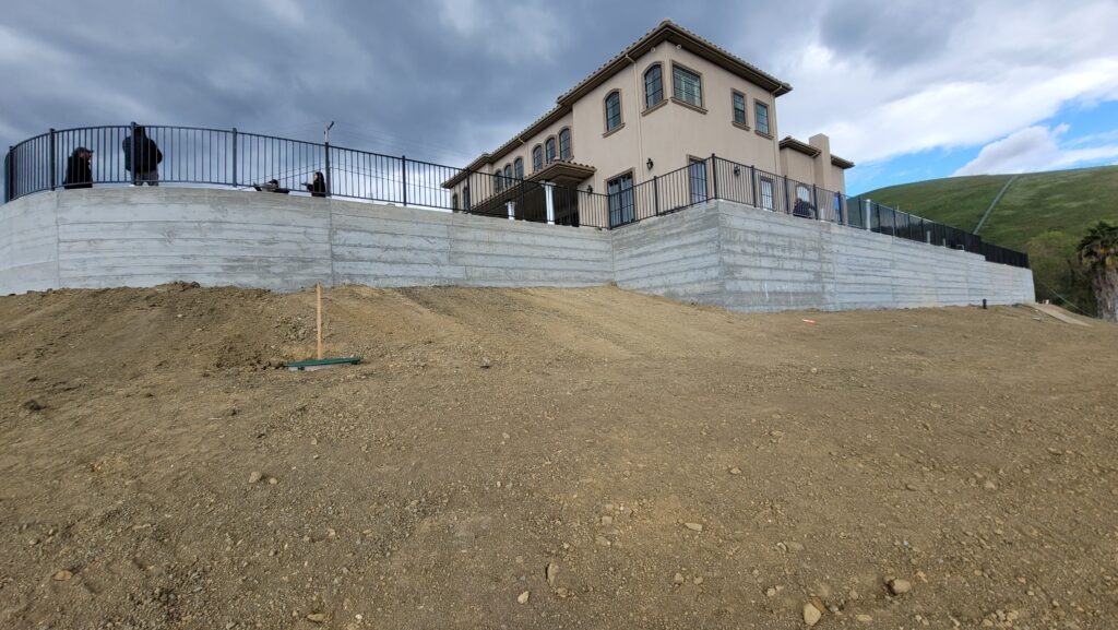 Finished curved concrete retaining wall with steel railing on hillside property in Milpitas California near San Jose Santa Clara County Image 2