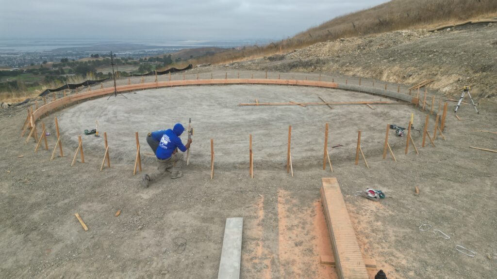 All Access Construction leveling and laying out circular water tank foundation on hillside property in Milpitas