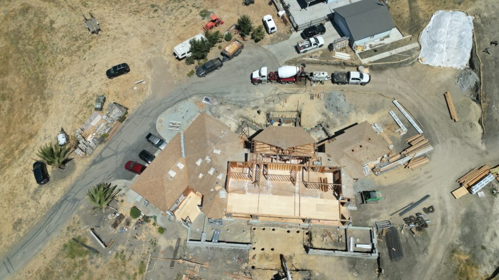 Aerial drone shot showing concrete trucks and full site setup for structural foundation pour in Milpitas – Milpitas