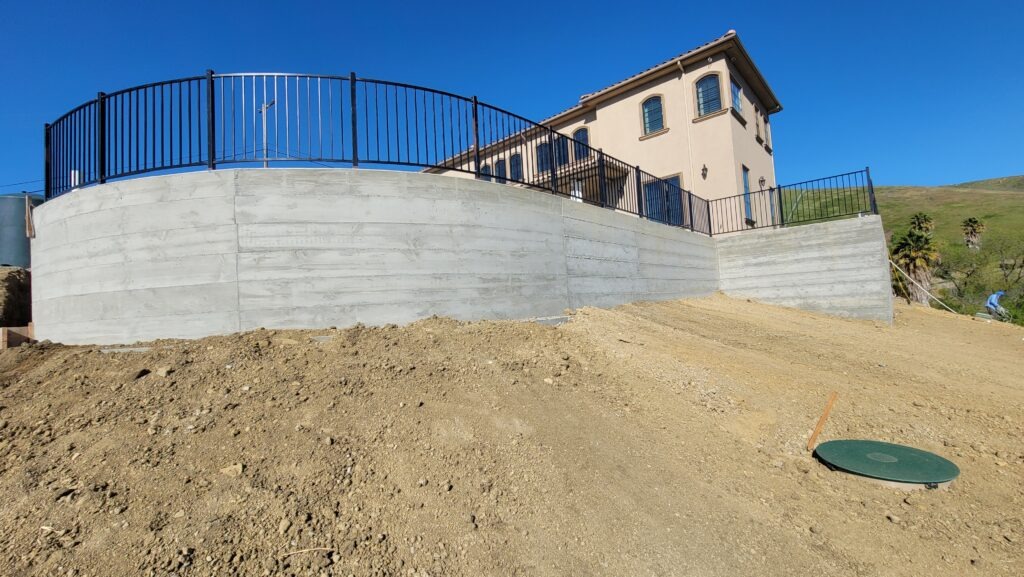 6 foot tall curved concrete retaining wall with smooth form finish in Milpitas CA Santa Clara County